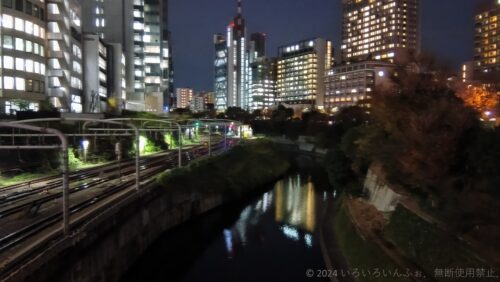 AQUOS wish4の写真作例。夜間のビル、川が写っている。AI処理により電車が消えた。